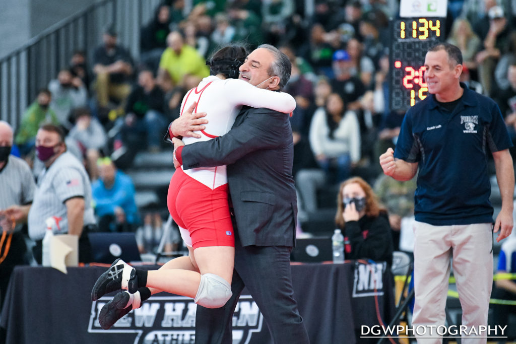 Foran High's Kelly Aspras leaps into the arms of coach Dave Esposito after winning the 138 lb title at the CT State Wrestling Open